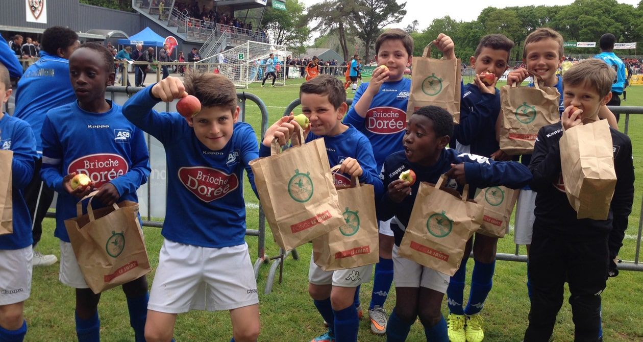 Enfants footballeurs qui prennent un goûter avec le Fonds le Saint